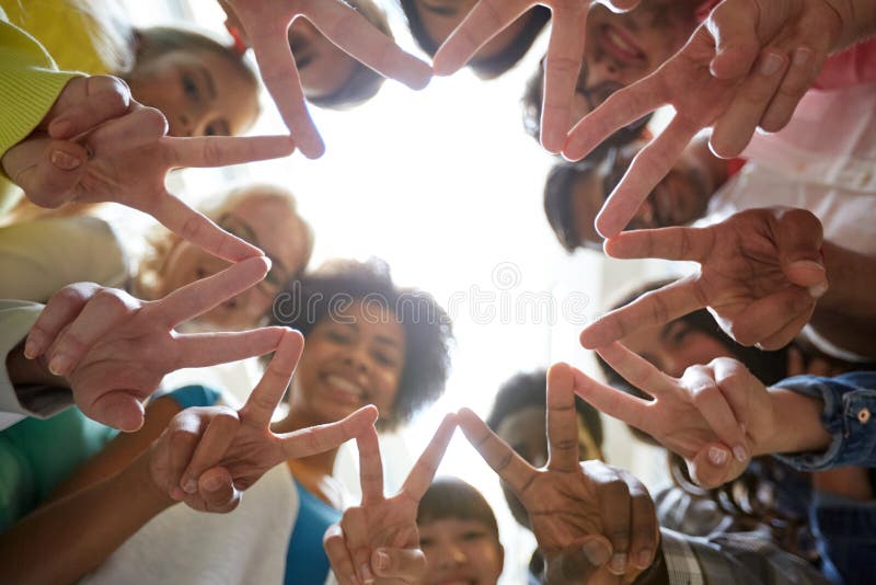 Studenti internazionali che mostrano pace o il segno di v fotografia stock Studenti internazionali che mostrano pace o il segno di v fotografia stock