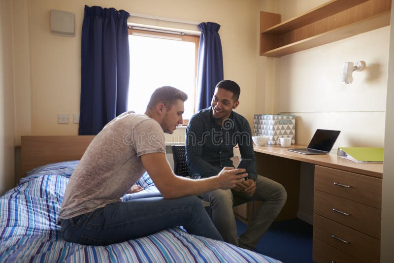 Male Students Working In Bedroom Of Campus Accommodation. Male Students Working In Bedroom Of Campus Accommodation