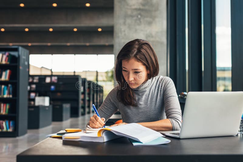 Studentin, die an der Collegebibliothek studiert lizenzfreies stockfoto