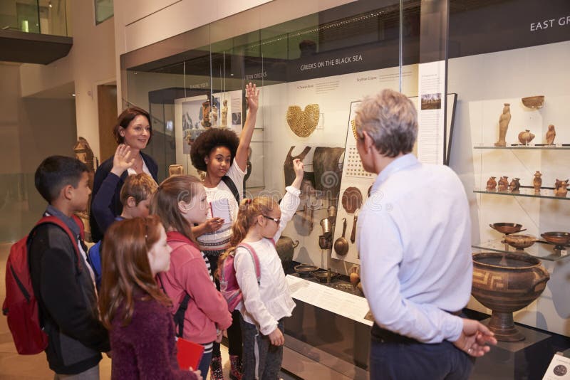 Students Looking At Artifacts In Case On Trip To Museum