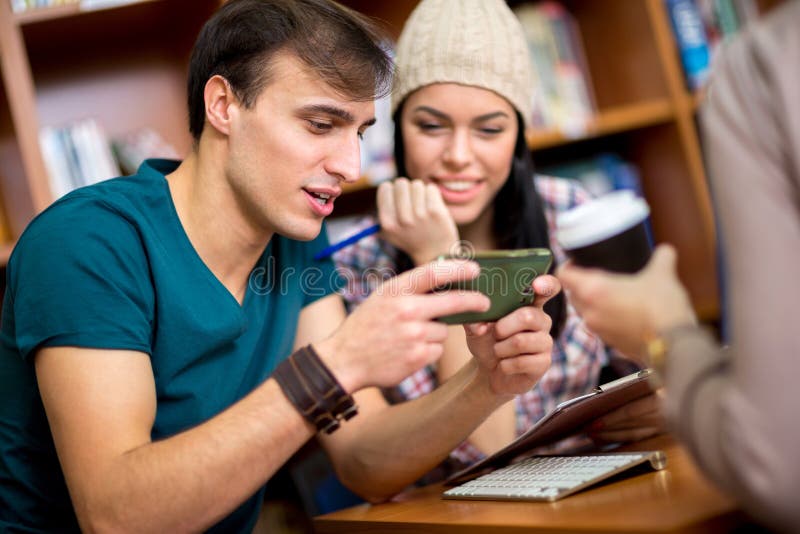 Students looking in funny message on mobile phone