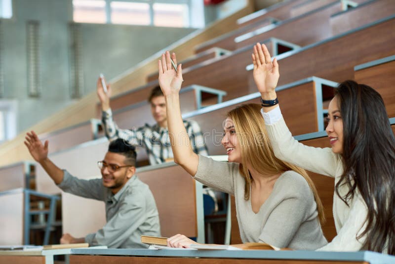 Students Raising Hands in Class stock images