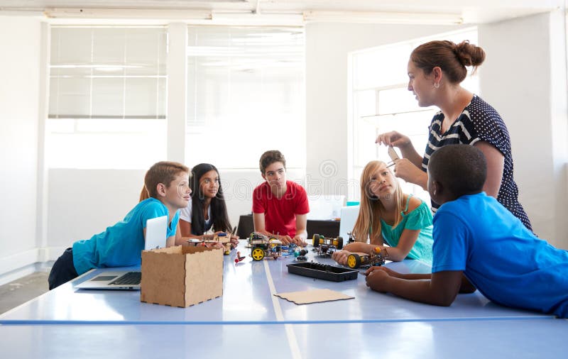 Students In After School Computer Coding Class Building And Learning To Program Robot Vehicle royalty free stock photo