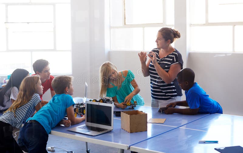 Students In After School Computer Coding Class Building And Learning To Program Robot Vehicle royalty free stock photos