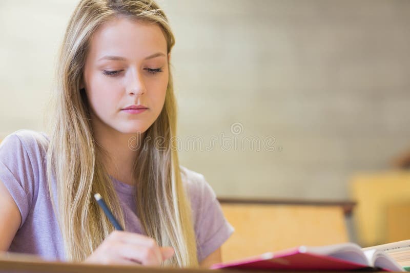 Students sitting beside each other while learning stock photography