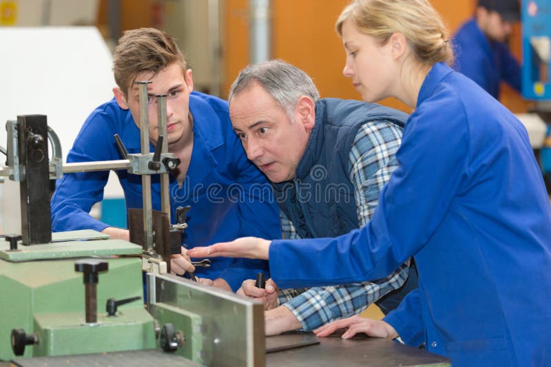Students with teacher looking at machine royalty free stock image