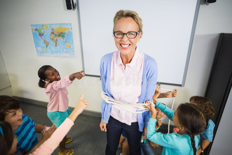 Students Tying Up a Teacher with Rope in Classroom Stock Photo Image of learning, innocence