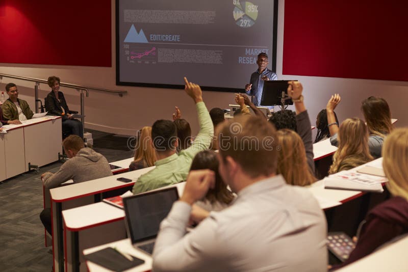 Students at university lecture raise hands to ask questions