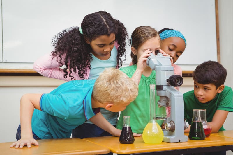 Students using science beakers and a microscope stock photography