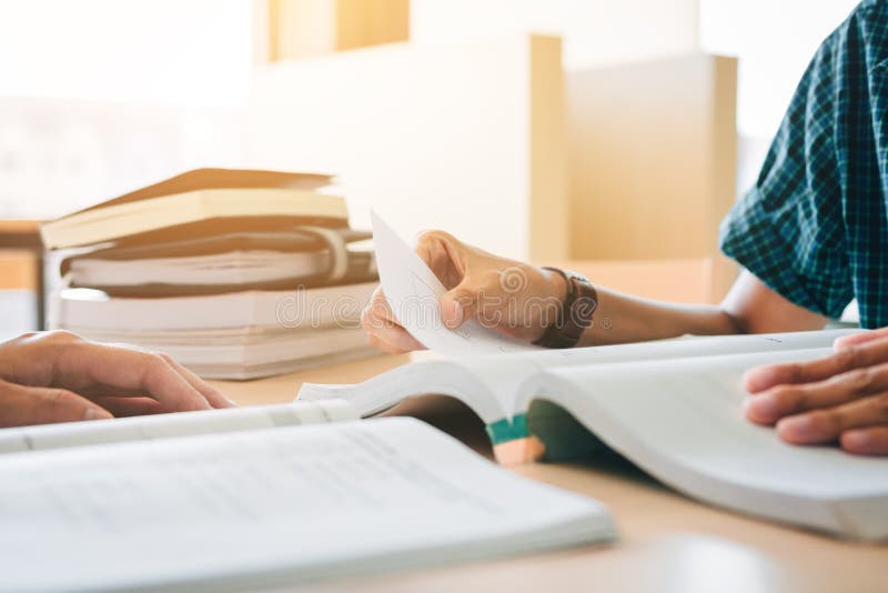 Students in Usniversity Uniforms Sitting at Desk in School Libra Stock