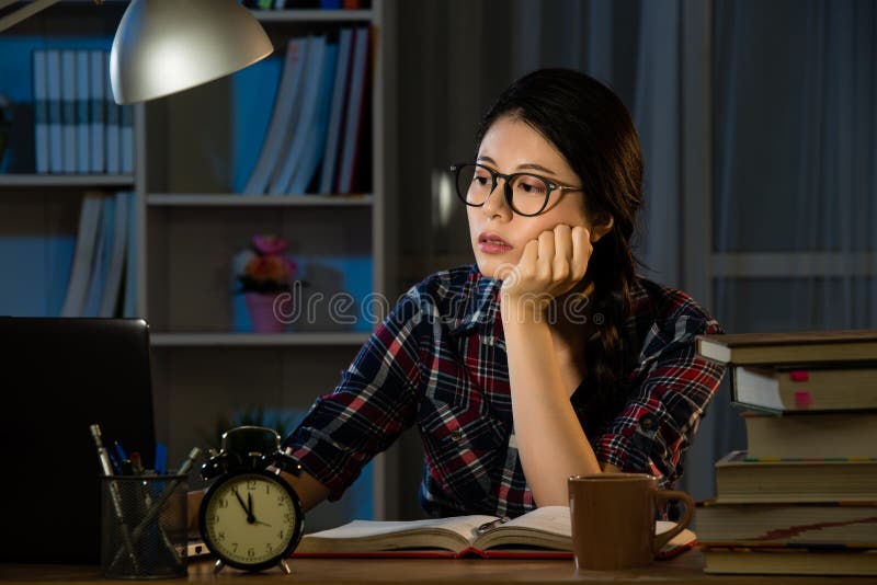 Studies late at night staying up late. Young exhausted concentrated student feel sleepy at the desk in her room in the dark at the lamp. mixed race asian chinese model. Studies late at night staying up late. Young exhausted concentrated student feel sleepy at the desk in her room in the dark at the lamp. mixed race asian chinese model.