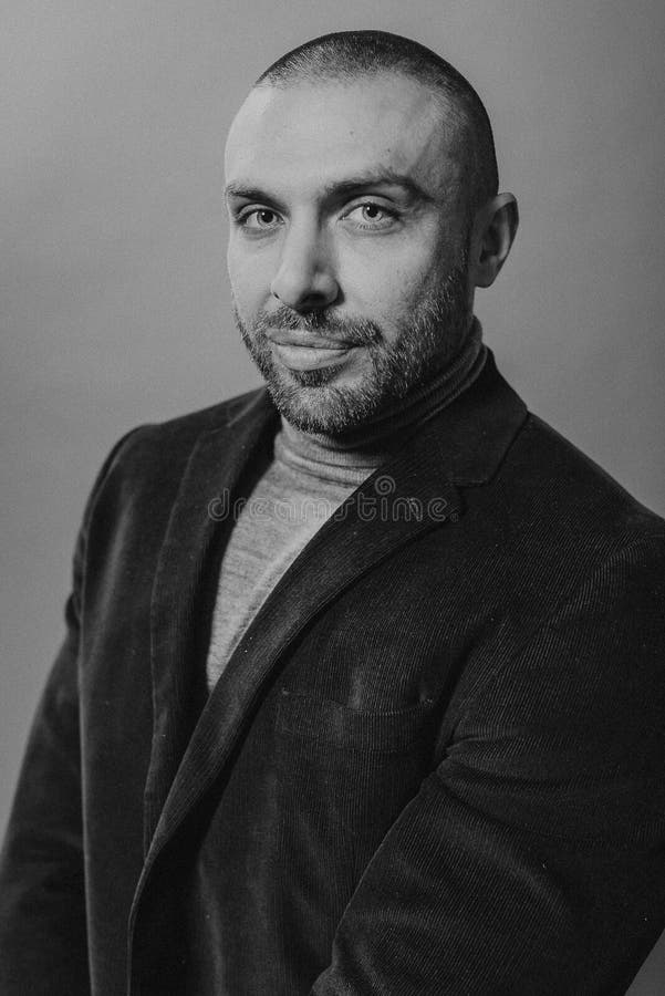 Studio fashion portrait in monochrome. Elegant young handsome serious man opened his jacket stock photos Studio fashion portrait in monochrome. Elegant young handsome serious man opened his jacket stock photos