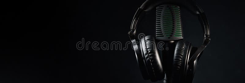 Studio microphone and headphones on black background. Online podcast concept royalty free stock photo