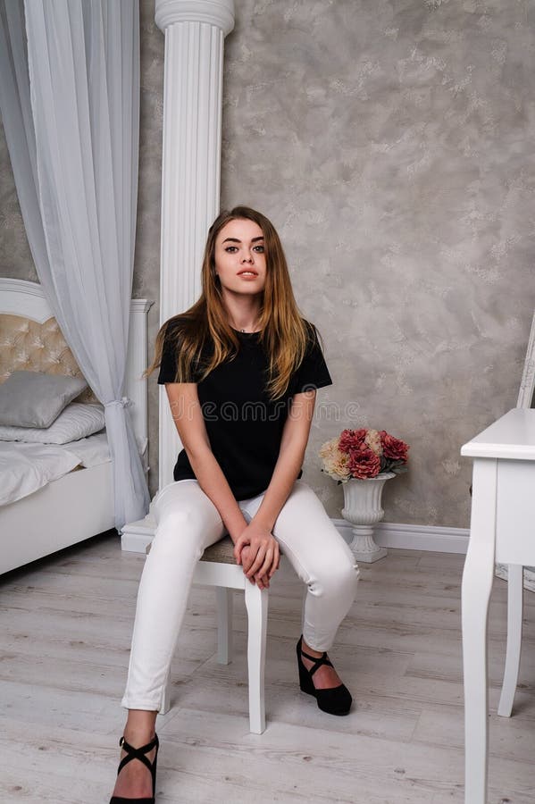 Studio photo of a young girl in a black T-shirt and white pants royalty free stock photo Studio photo of a young girl in a black T-shirt and white pants royalty free stock photo