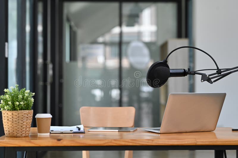 Studio podcast wnętrze z profesjonalnym mikrofonem kondensacyjnym i laptopem na drewnianym stole. technologii i audio fotografia stock