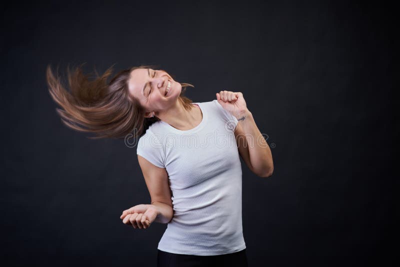 Studio portrait on a black background of a young athletic girl dancing and having fun. stock photography Studio portrait on a black background of a young athletic girl dancing and having fun. stock photography