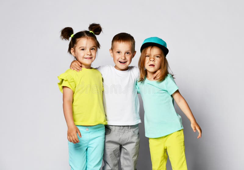 Full Body Shot Of Three Children In Bright Clothes Two Girls And