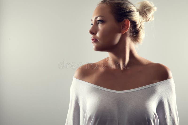 Studio portrait of gorgeous woman with blonde hair and white t-shirt.