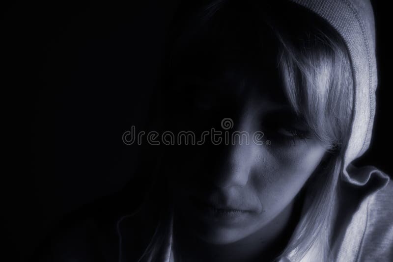 Studio portrait of a long blond girl in the dark