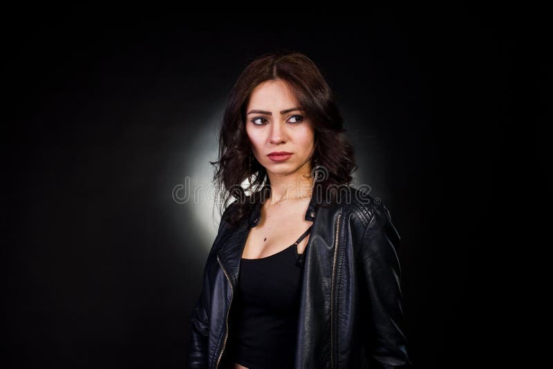 Studio portrait of sexy brunette girl in black leather jacket