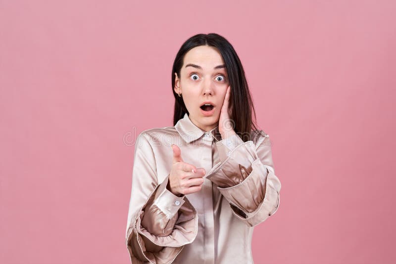 Studio portrait of a shocked funny brunette girl widely opened her eyes and mouth in surprise. royalty free stock photo Studio portrait of a shocked funny brunette girl widely opened her eyes and mouth in surprise. royalty free stock photo