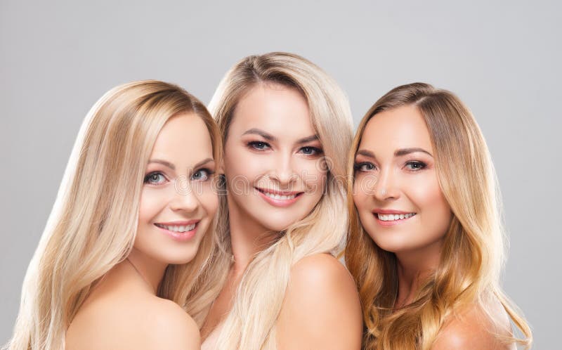 Studio portrait of young, beautiful and natural blond women over grey background. Close-up of smiling girls. Face royalty free stock photo Studio portrait of young, beautiful and natural blond women over grey background. Close-up of smiling girls. Face royalty free stock photo