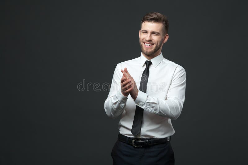 Studio portrait of young happy handsome businessman claping hand