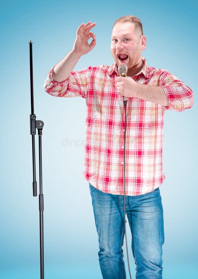 Studio portrait of a young showman with the microphone