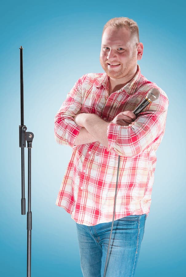 Studio portrait of a young showman with the microphone