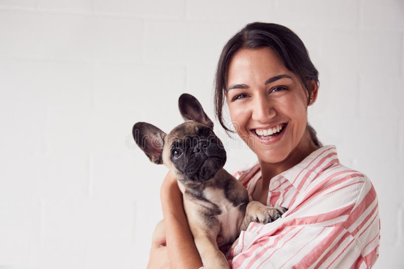 Studio Portret Uśmiechniętej Młodej Kobiecie Holding Affectionate Pet French Bulldog zdjęcia stock