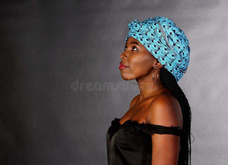 Black young girl in blue head scarf looking up