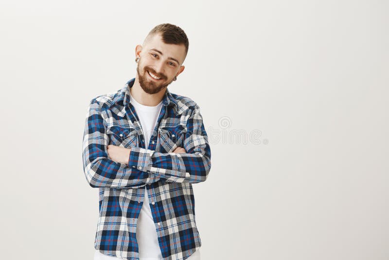 Studio shot of friendly handsome young boyfriend with beard, standing with crossed hands and smiling joyfully, blushing stock photos Studio shot of friendly handsome young boyfriend with beard, standing with crossed hands and smiling joyfully, blushing stock photos