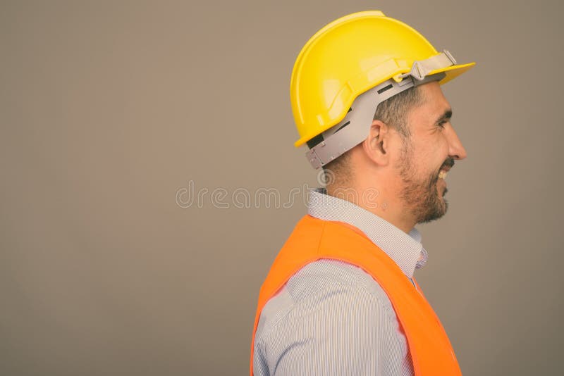 Handsome bearded Persian man construction worker against gray background stock image Handsome bearded Persian man construction worker against gray background stock image