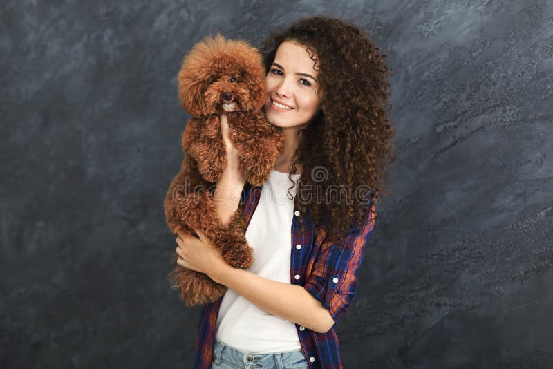 Studio shot of happy woman with cute curly dog stock photos Studio shot of happy woman with cute curly dog stock photos