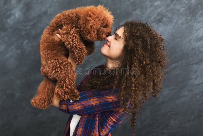 Studio shot of happy woman with cute curly dog stock photos Studio shot of happy woman with cute curly dog stock photos