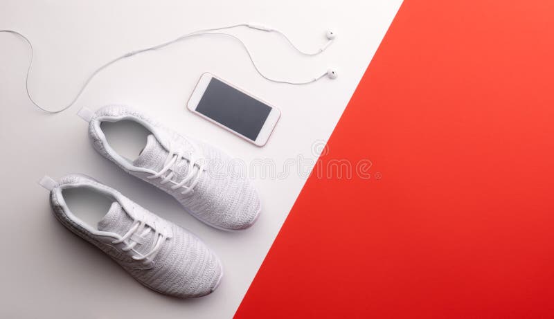 A studio shot of running shoes and smartphone on color background. Flat lay. A studio shot of running shoes, earphones and smartphone on color background. Flat royalty free stock photos A studio shot of running shoes and smartphone on color background. Flat lay. A studio shot of running shoes, earphones and smartphone on color background. Flat royalty free stock photos