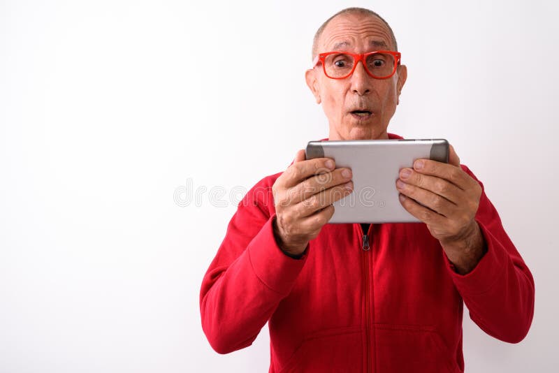 Studio shot of shocked bald senior man using digital tablet whil royalty free stock photos Studio shot of shocked bald senior man using digital tablet whil royalty free stock photos