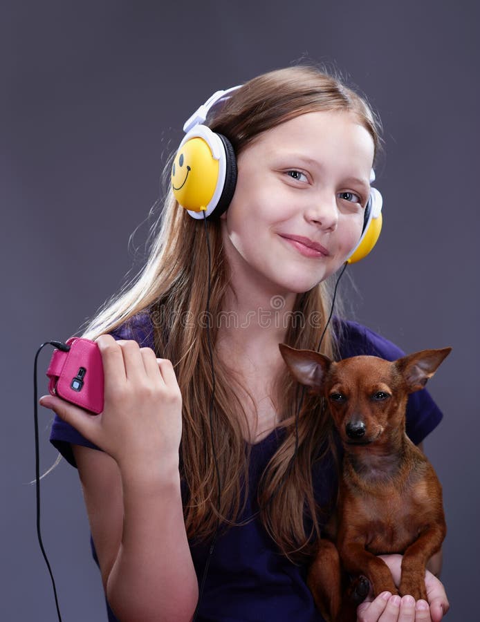 Studio Shot Of A Smiling Teen Girl With Headphones And Doggy Stock ... picture