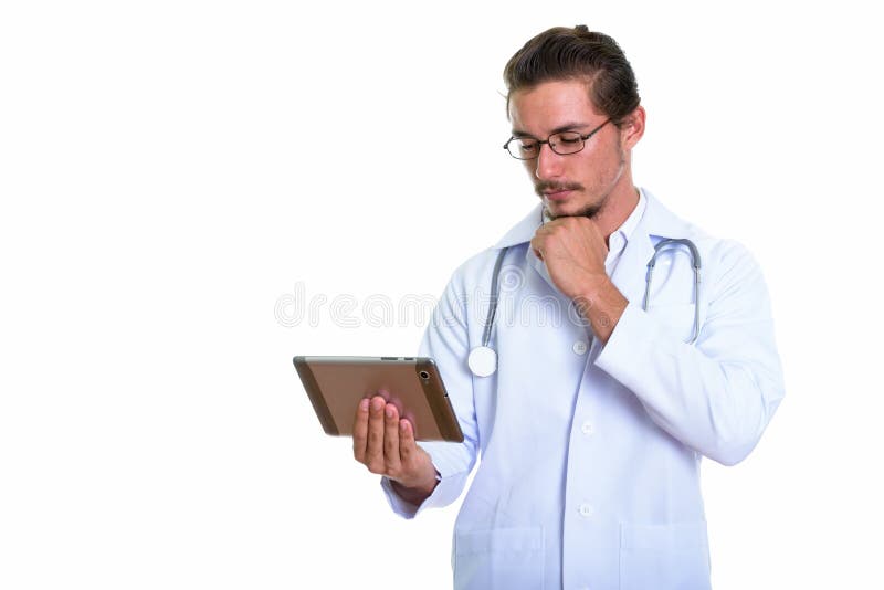 Studio Shot Of Young Handsome Man Doctor Using Digital Tablet Wh Stock ...