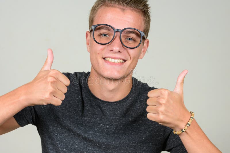 Studio shot of young handsome nerd man with blond hair wearing eyeglasses against white background. Studio shot of young handsome nerd man with blond hair wearing eyeglasses against white background