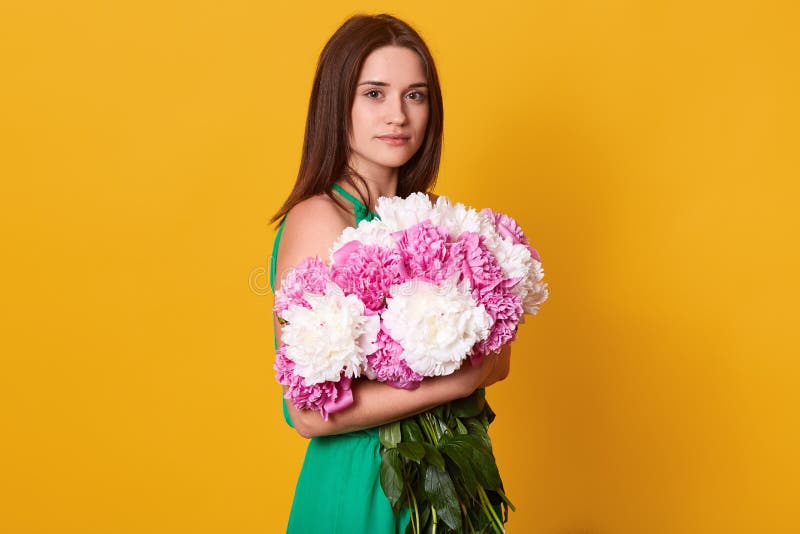 Studio strzał pięknego brunetki żeńskiego obejmowania duży bukiet z różowymi i białymi peoniami, elegancka kobieta z kwiatami, sp obrazy stock Studio strzał pięknego brunetki żeńskiego obejmowania duży bukiet z różowymi i białymi peoniami, elegancka kobieta z kwiatami, sp obrazy stock
