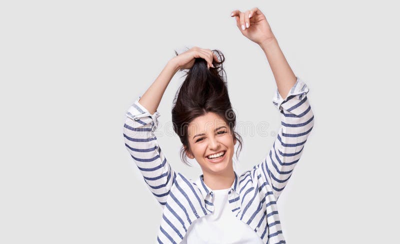 Studiobeeld die van het vrolijke donkerbruine vrouw spelen met en haar die, over witte achtergrond stellen glimlachen lachen royalty-vrije stock fotografie Studiobeeld die van het vrolijke donkerbruine vrouw spelen met en haar die, over witte achtergrond stellen glimlachen lachen royalty-vrije stock fotografie
