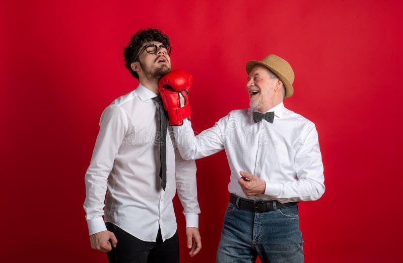 Studiofoto von jung und alt, Vater und Sohn mit Boxhandschuh lizenzfreies stockbild Studiofoto von jung und alt, Vater und Sohn mit Boxhandschuh lizenzfreies stockbild