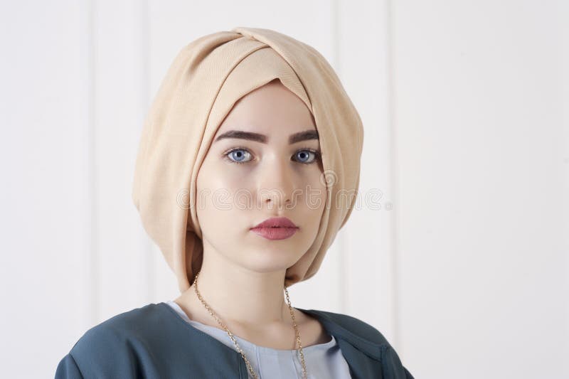 Studiofotoet av en östlig ung kvinna skriver in den moderna muslimska kläderna och den härliga huvudbonaden royaltyfri foto Studiofotoet av en östlig ung kvinna skriver in den moderna muslimska kläderna och den härliga huvudbonaden royaltyfri foto