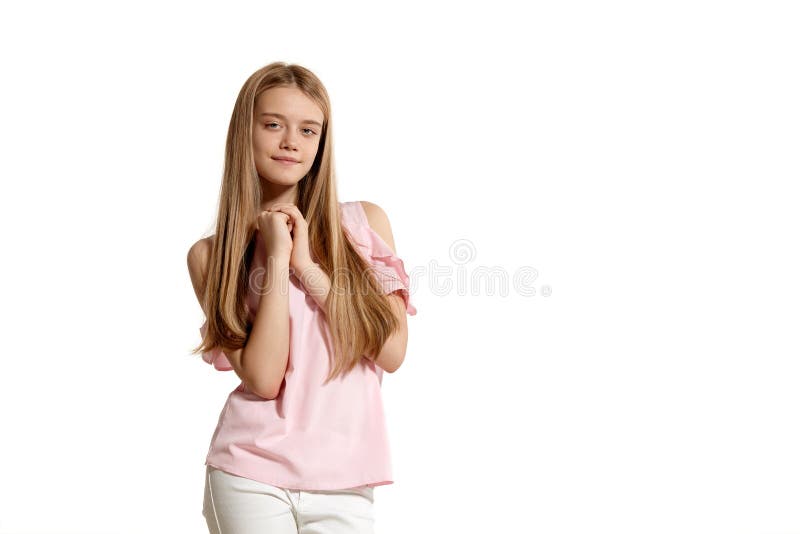 Studioportret van een mooie tiener van het meisjesblonde in het roze t-shirt stellen geïsoleerd op witte achtergrond royalty-vrije stock afbeeldingen Studioportret van een mooie tiener van het meisjesblonde in het roze t-shirt stellen geïsoleerd op witte achtergrond royalty-vrije stock afbeeldingen