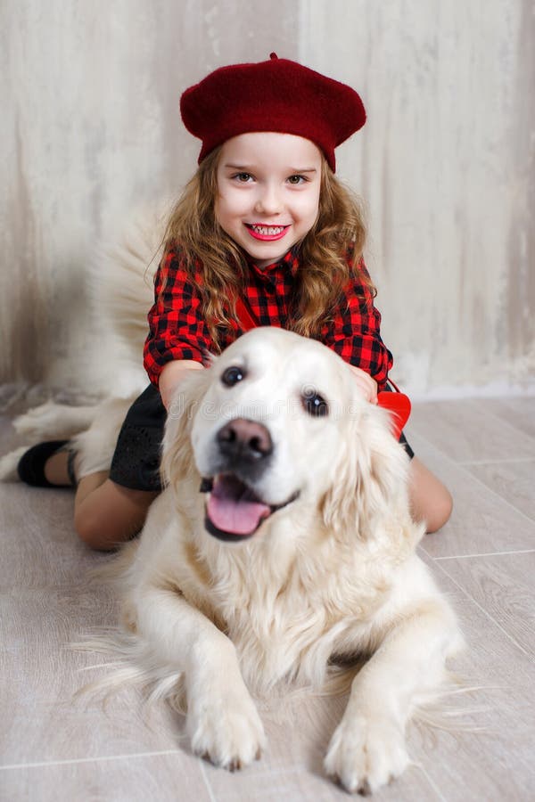 Studioporträt eines Mädchens mit einem Hund auf einem grauen Hintergrund lizenzfreies stockbild Studioporträt eines Mädchens mit einem Hund auf einem grauen Hintergrund lizenzfreies stockbild