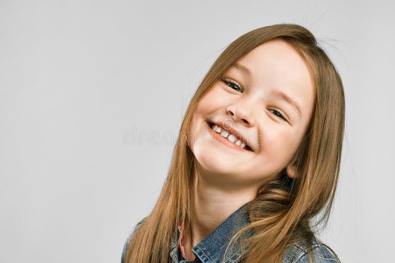 Studioporträt von einem netten wenig Mädchen auf einem grauen Hintergrund Kinderlächeln