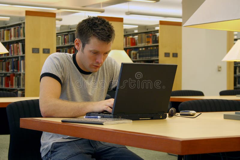 Student studovat s notebookem v knihovně.