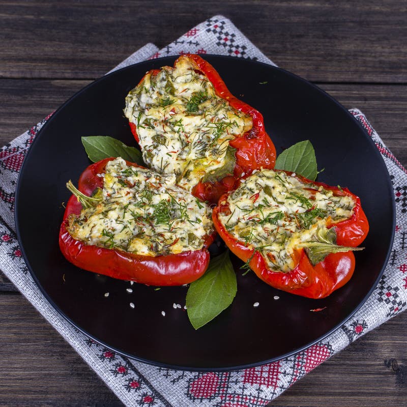 Stuffed red peppers in black plate