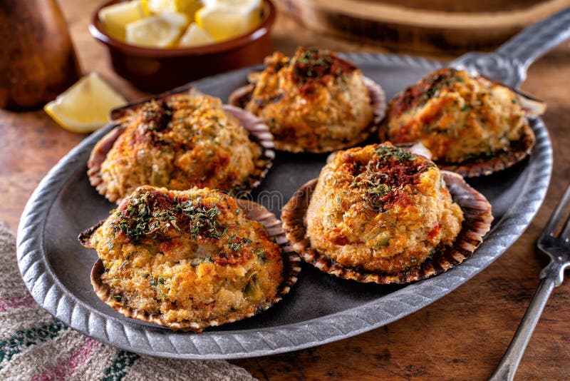 Delicious stuffed scallops on the half shell with celery, breadcrumbs and paprika. Bivalve shell stock images, royalty-free photos and pictures